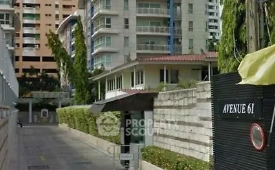 Modern residential building with lush greenery and secure entrance at Avenue 61.