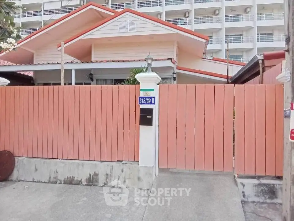 Charming single-story home with a pink fence and modern exterior design.