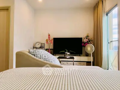Cozy living room with modern decor and large TV, perfect for relaxation.