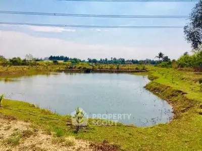 Scenic view of a serene pond surrounded by lush greenery, perfect for tranquil living or development.
