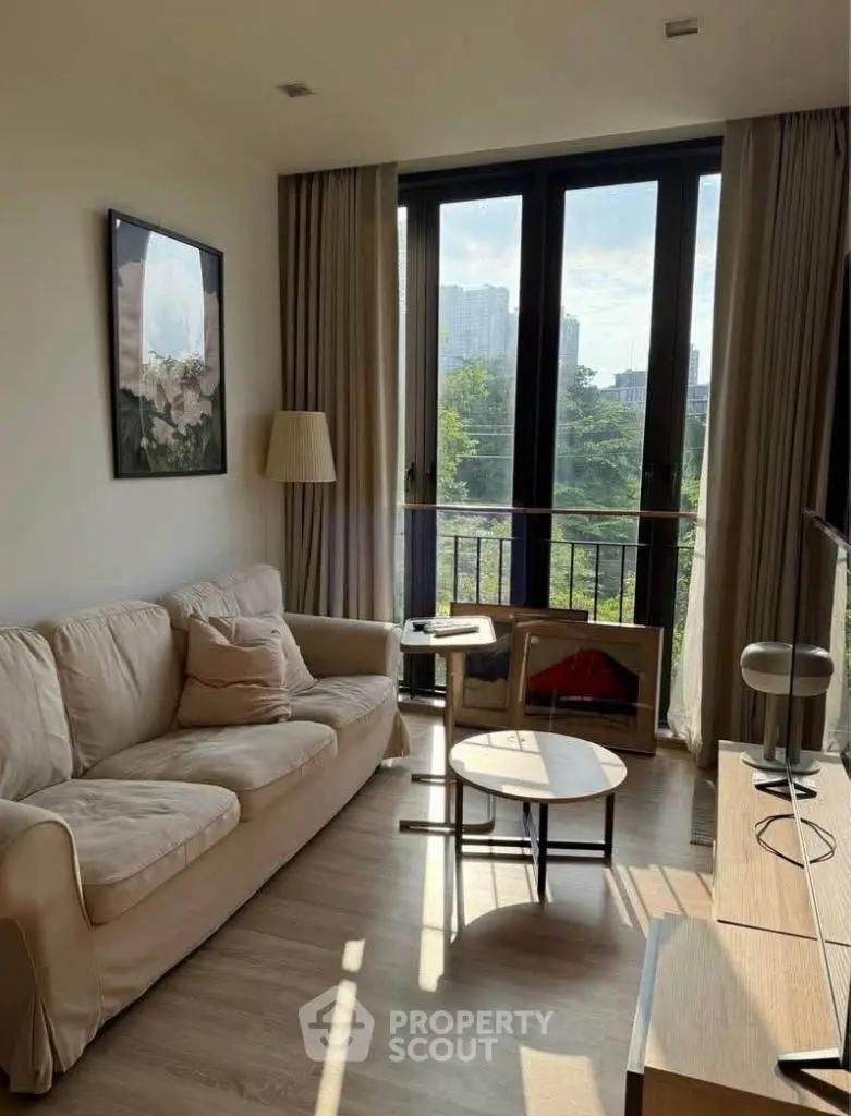 Charming living room with cozy sofa and large windows offering a stunning view of the city skyline.
