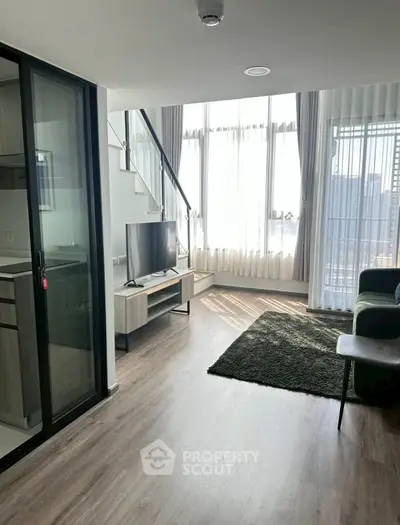 Modern duplex living room with large windows and stylish decor