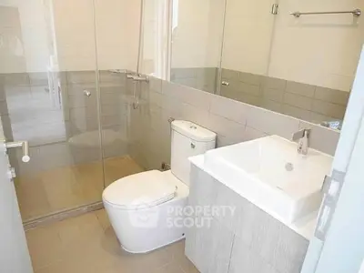 Modern bathroom with glass shower and sleek fixtures in a contemporary home.