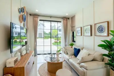 Charming living room with cozy decor and large window view of lush garden