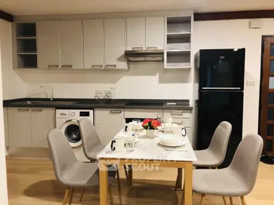Modern kitchen with dining area, sleek cabinets, and appliances in a cozy open layout.