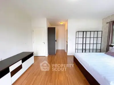Spacious bedroom with modern furnishings and wooden flooring