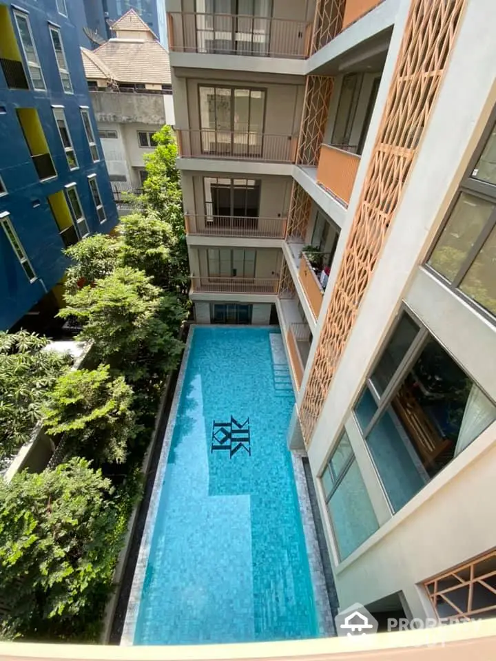 Modern apartment building with a stunning pool view and lush greenery