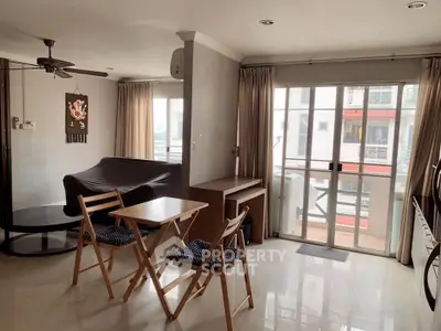 Spacious living room with large windows and modern furniture in a bright apartment.