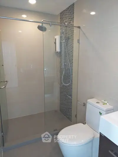 Modern bathroom with glass shower enclosure and sleek fixtures