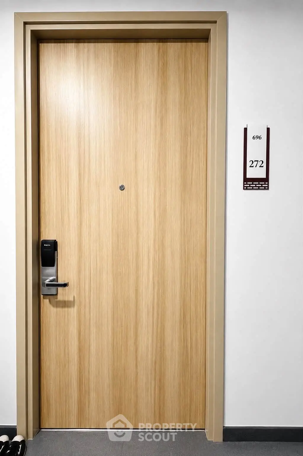 Modern apartment door with electronic lock and room number, showcasing secure and stylish entryway.