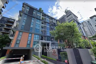 Modern urban apartment building with lush greenery and stylish facade in vibrant city setting.