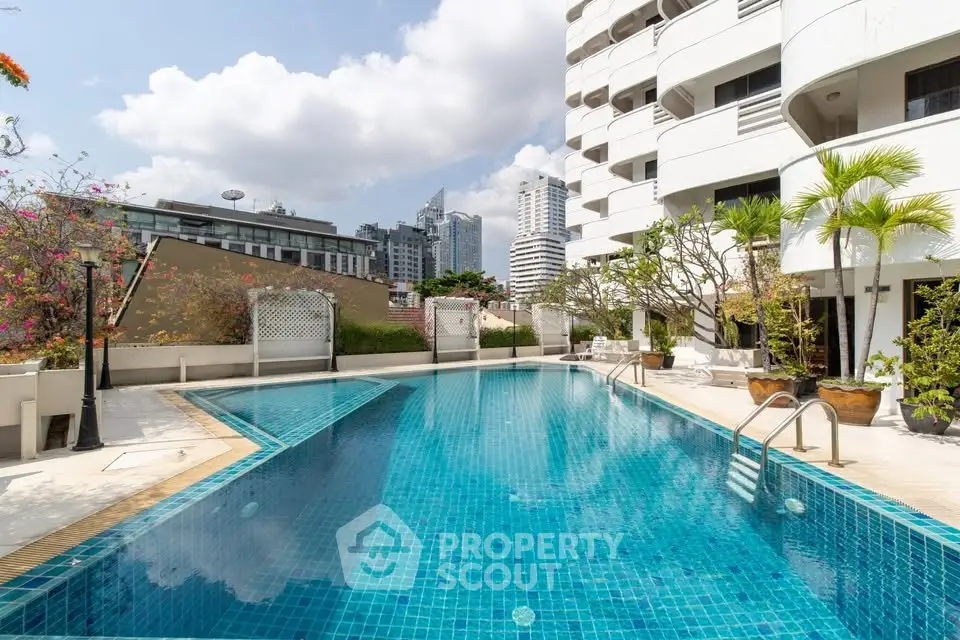 Luxurious urban apartment complex with stunning outdoor pool and city skyline views.