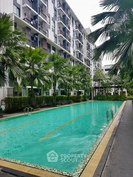 Luxurious condominium with a pristine swimming pool and lush greenery, perfect for relaxation and leisure.