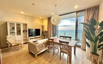 Stunning living room with ocean view, elegant decor, and spacious balcony access.
