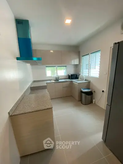 Modern kitchen with sleek cabinets and granite countertops in a bright, airy space.