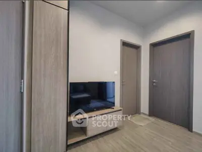 Modern living room with sleek wooden furniture and flat-screen TV, perfect for cozy relaxation.
