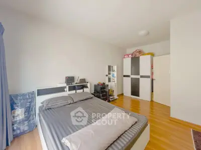 Spacious bedroom with modern decor and ample storage in a cozy apartment.