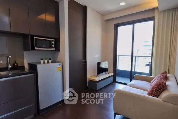 Modern living room with kitchenette and balcony in urban apartment