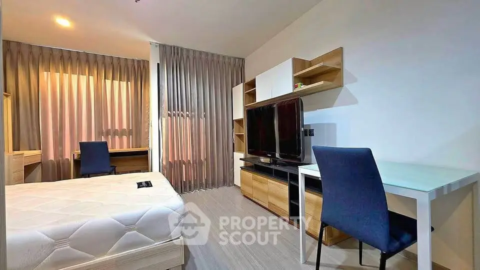 Modern bedroom with study area, featuring sleek furniture and natural light.