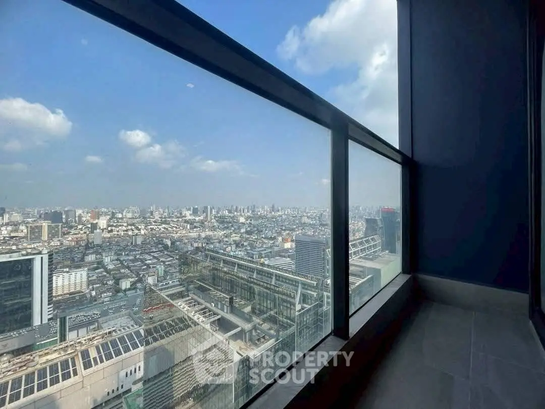 Stunning cityscape view from high-rise balcony with expansive glass railing.