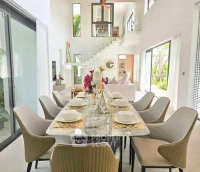 Luxurious open-plan living and dining area with elegant decor and high ceilings