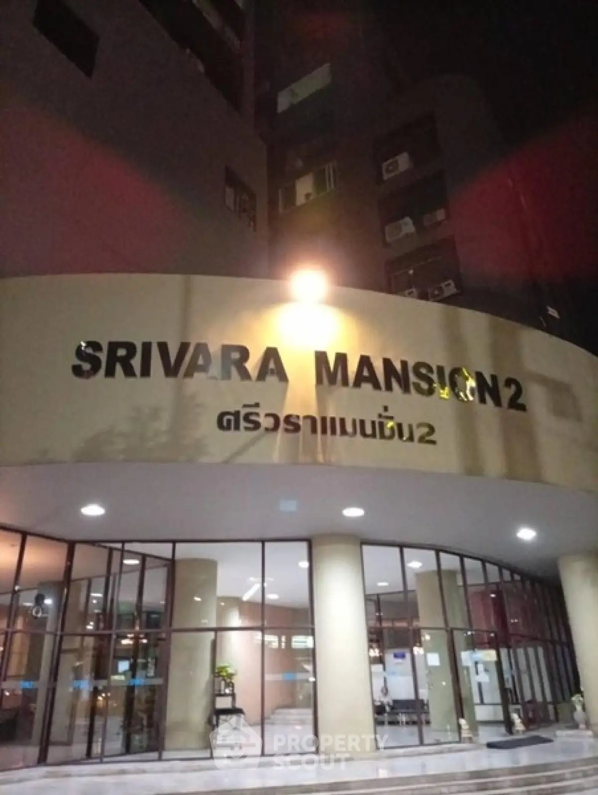 Exterior view of Srivara Mansion 2 entrance at night with illuminated signage.