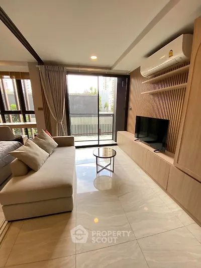 Modern living room with sleek design and large windows offering city views.