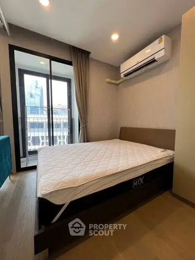 Modern bedroom with balcony view and air conditioning in urban apartment