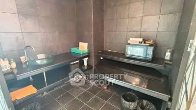 Modern kitchen with sleek black tile design and microwave oven