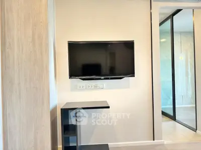 Modern living room with wall-mounted TV and sleek design elements.