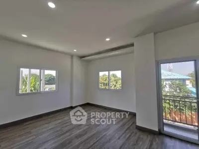 Spacious empty room with large windows and balcony view, perfect for customization.