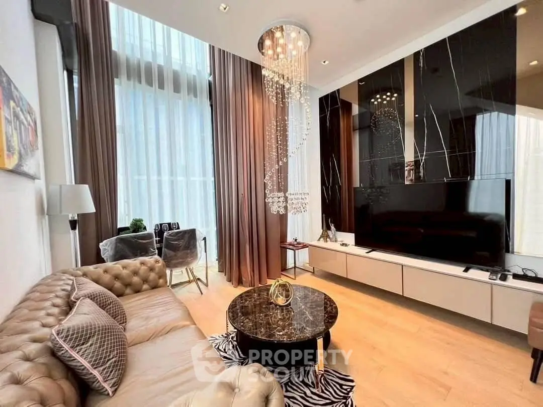 Luxurious living room with high ceilings, elegant chandelier, and modern decor.