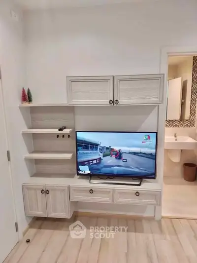 Modern living room with stylish TV unit and open bathroom view, showcasing elegant interior design.