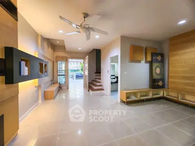 Spacious modern living room with elegant built-in shelves and ceiling fan
