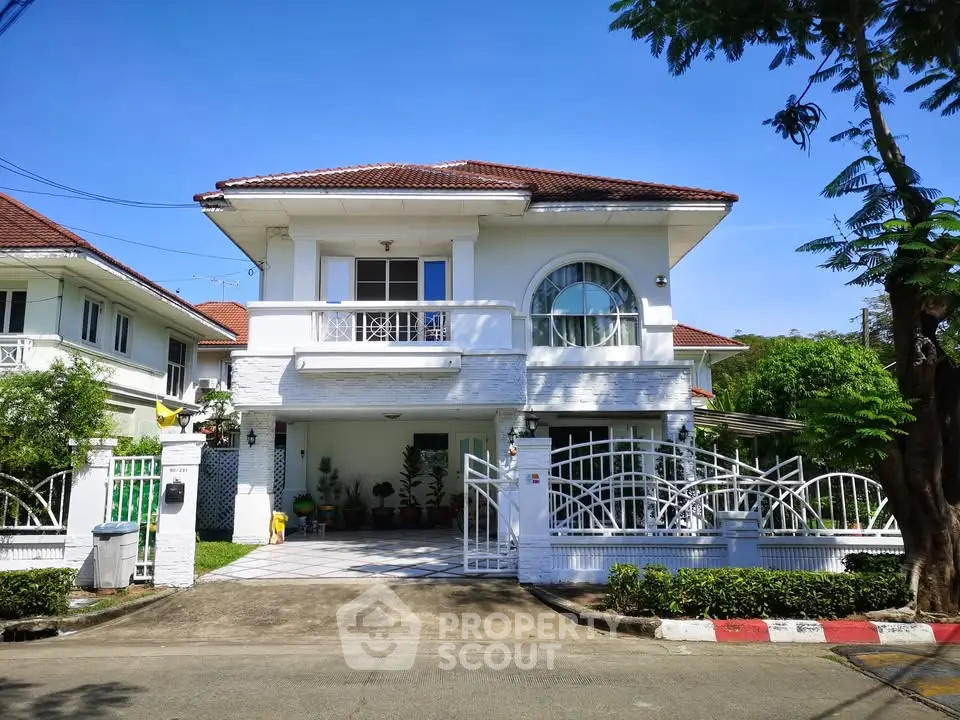 Charming two-story house with a spacious driveway and lush greenery in a serene neighborhood.