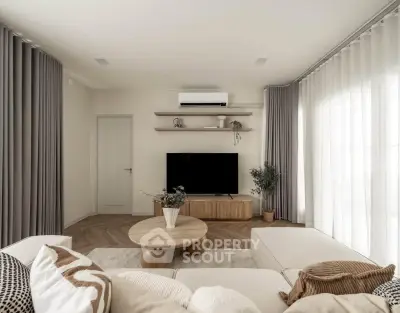 Modern living room with stylish decor, large windows, and cozy seating area.