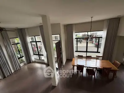 Spacious dining area with high ceilings and large windows offering abundant natural light.