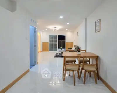 Spacious modern living and dining area with elegant decor and bright lighting.