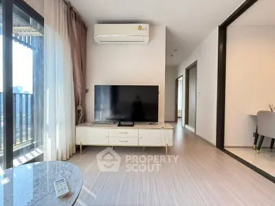 Modern living room with large TV and balcony view in stylish apartment