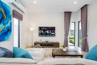 Modern living room with stylish decor, large windows, and wall-mounted TV for a cozy ambiance.