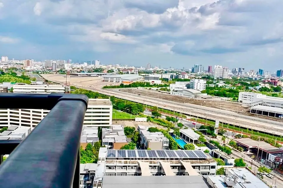 Stunning cityscape view from a high-rise balcony showcasing urban skyline and railway tracks.