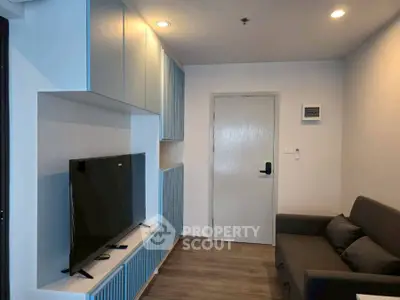 Modern living room with sleek cabinetry and flat-screen TV, featuring cozy sofa and ambient lighting.