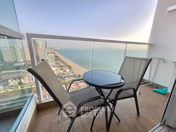 Stunning high-rise balcony with breathtaking ocean view and cozy seating area.