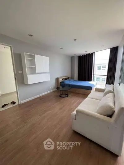 Spacious modern bedroom with large window and stylish furniture