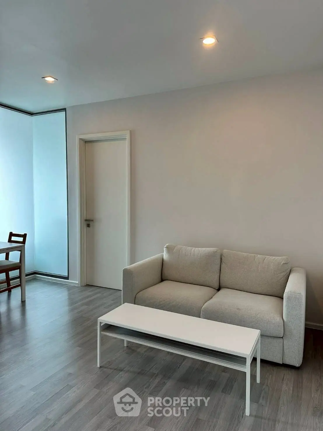 Modern living room with minimalist design, featuring a cozy sofa and sleek coffee table.