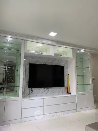 Modern living room with sleek TV unit and glass cabinets, perfect for stylish home entertainment.
