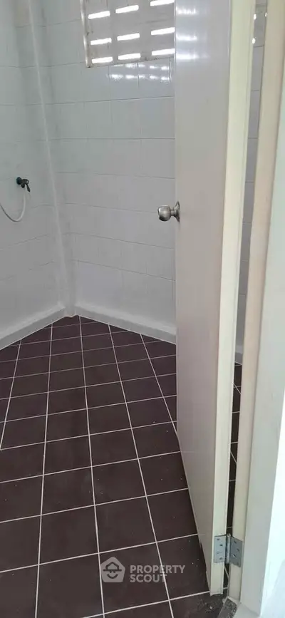 Minimalist bathroom with tiled floor and partially open door