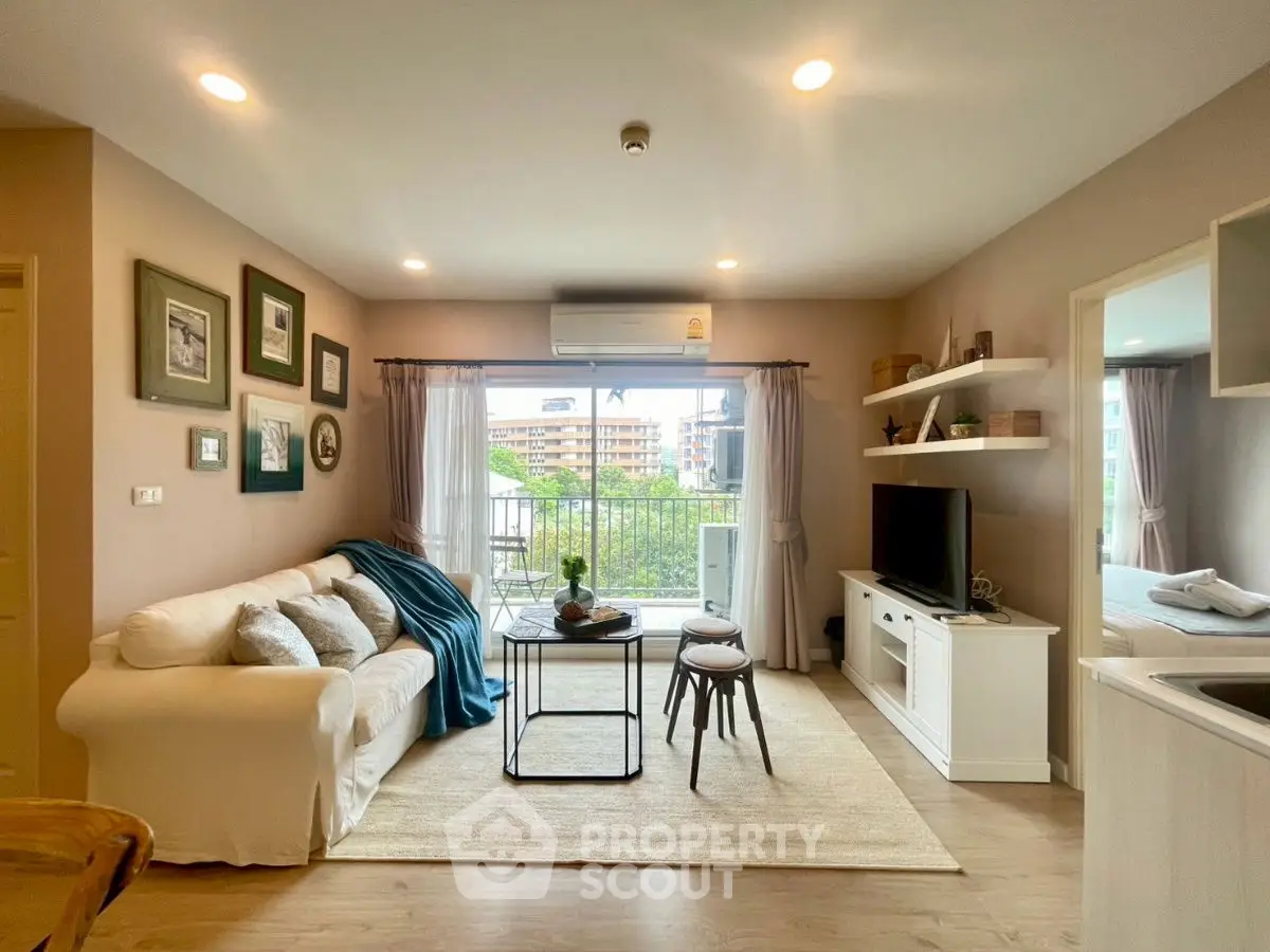 Charming living room with cozy sofa and balcony view, perfect for relaxation.