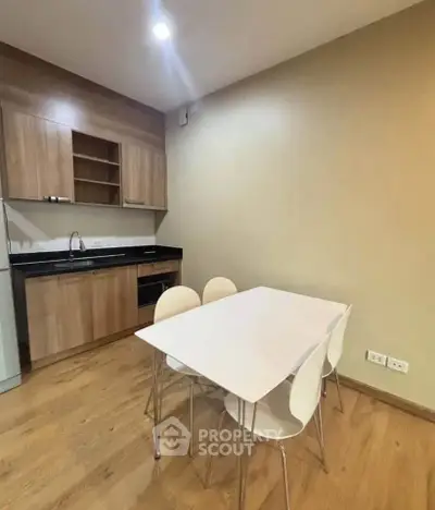 Modern kitchen with wooden cabinets and dining table in cozy apartment