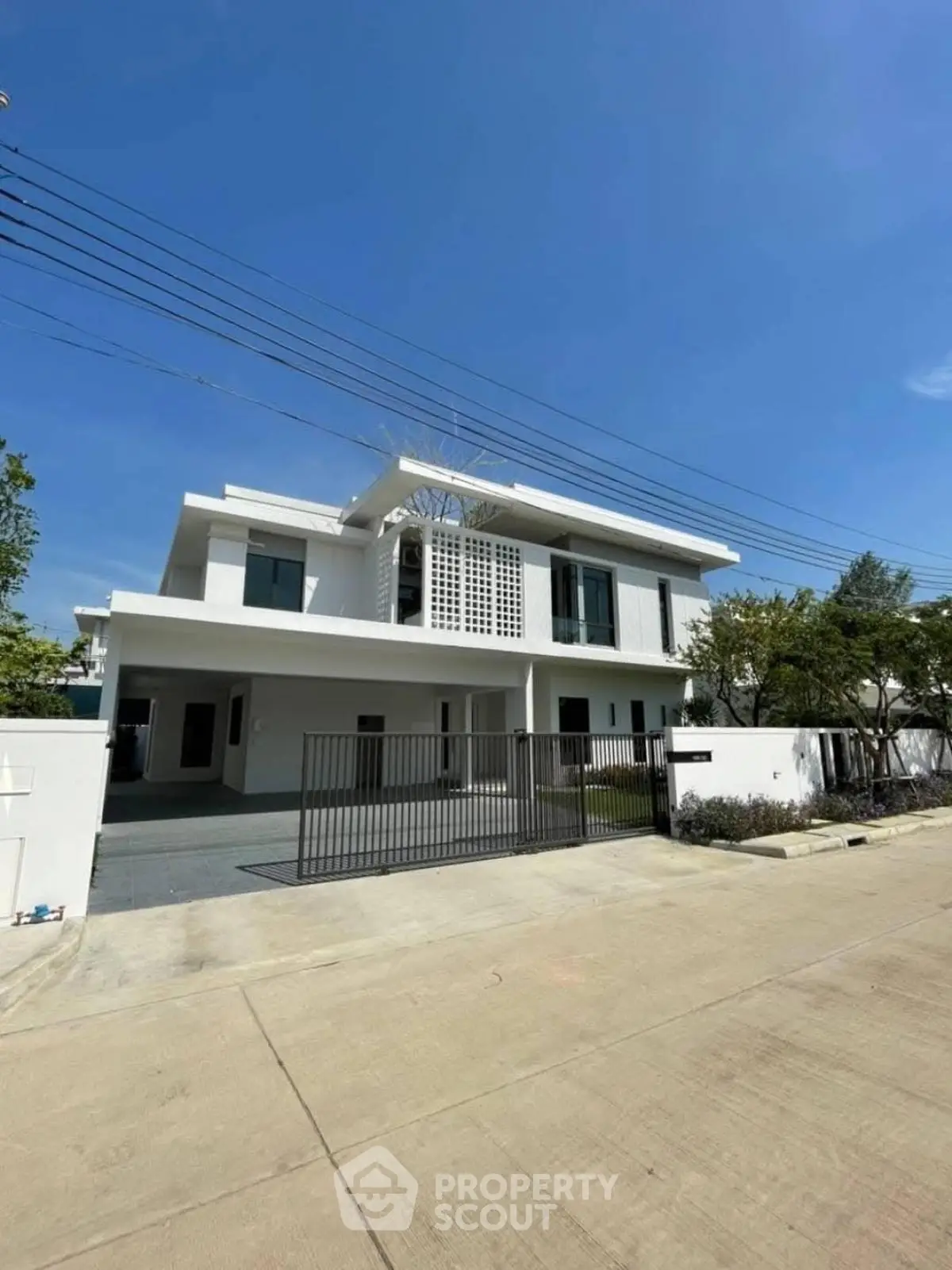 Stunning modern white villa with spacious driveway and lush greenery